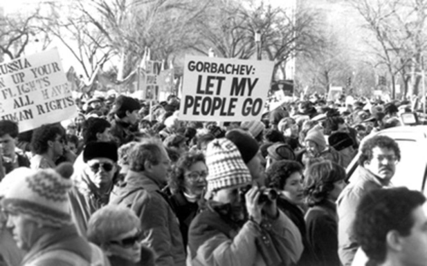 Black and white photo of the Freedom Sunday rally in Washington DC, featuring a crowd of mostly caucasian participants dressed in winter clothing. Center of the photo is a protest sight that reads: Gorbachev, LET MY PEOPLE GO