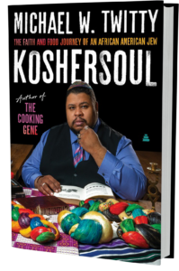 Front cover of Koshersoul featuring Michael Twitty holding a book while sitting at a table with several colorful challahs on the table in front of him.