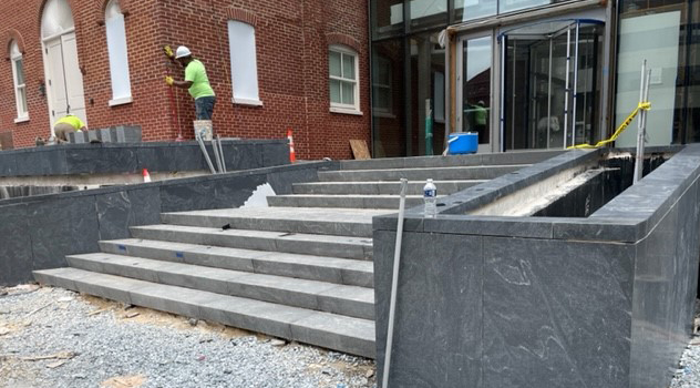 Exterior view of the construction site featuring the stone steps leading up to the main entrance.