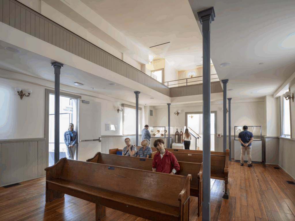 isitors in the historic Sanctuary and viewing the Judaica in cases, Fall 2024. Alex Fradkin Photography