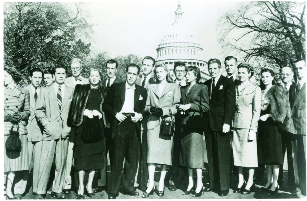 Black and white photo of Hollywood celebrities standing together with the dome of the Capitol building behind them.