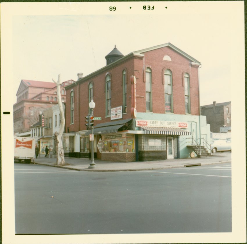 Faded color photograph of the synagogue building with the first floor used as a storefront.